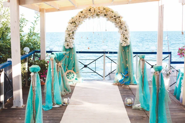 Bröllop på stranden. Vacker bröllopsbåge, dekorerad med blommor. Havet. Havet. — Stockfoto