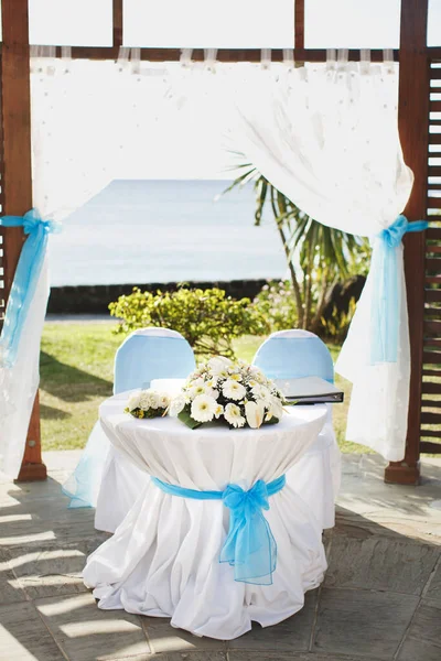 Bord för målning med blommor i tält vid ett bröllop nära poolen på havet på ön. — Stockfoto