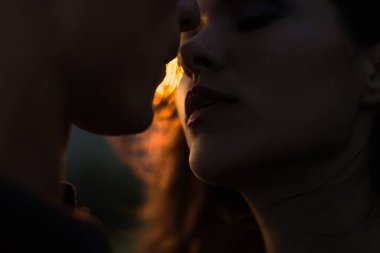 Gün batımında siluet sevgilileri. Gün batımında gün batımında genç bir çiftin siluetleri..