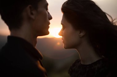 Gün batımında siluet sevgilileri. Gün batımında gün batımında genç bir çiftin siluetleri..