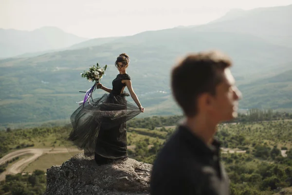 Mulher e homem de roupas pretas ao ar livre. Vestido de noiva preto . — Fotografia de Stock