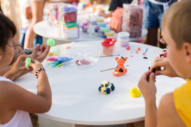 Çocukların elleri beyaz bir masanın üzerinde plastik kalıptan yapılır..