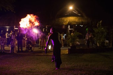Ateş sanatçısı karanlıkta ateş püskürtür..