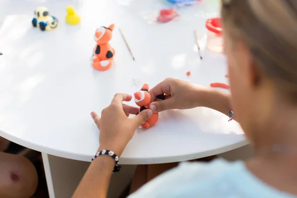 Детские руки формируются из пластилина на белом столе . — стоковое фото