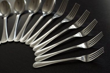 Siyah arka planda çatal bıçak takımı. Çatal, kaşık, bıçak.