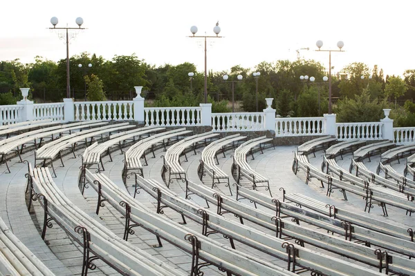 Row of wooden benches at summer theater in a city park. — Stock Photo, Image