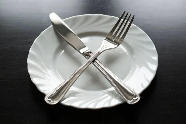 Cutlery on a black background. Fork, spoon, knife, plate. — Stock Photo, Image