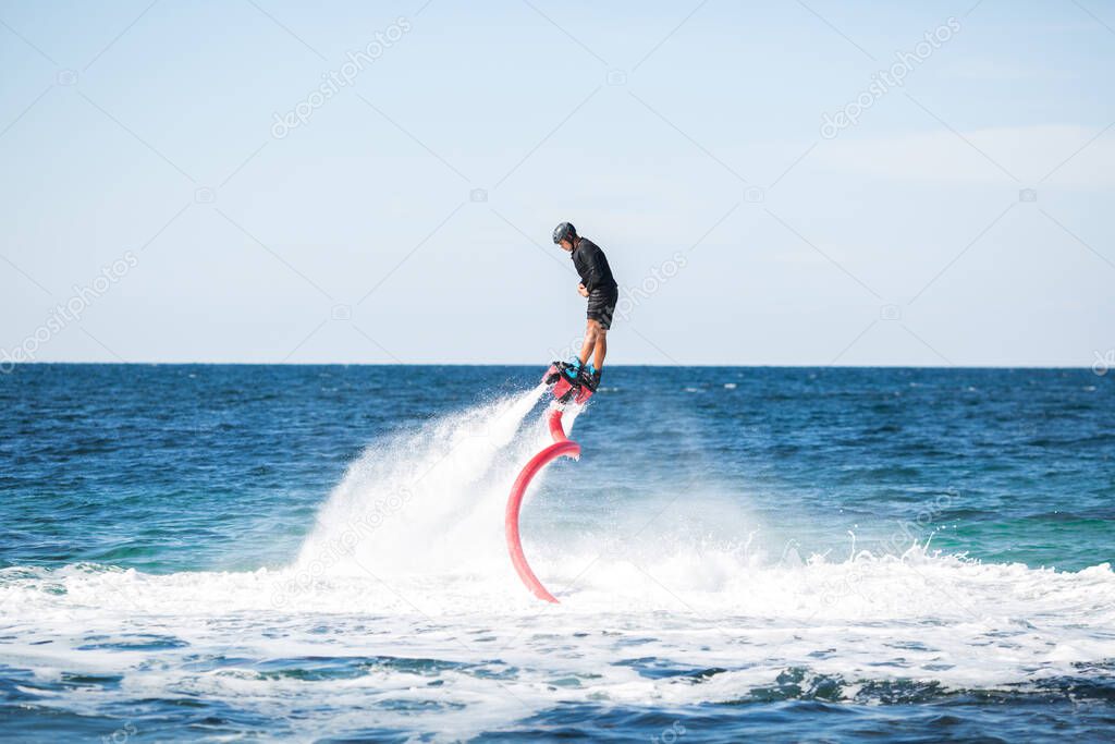 Silhouette of a fly board rider at sea.