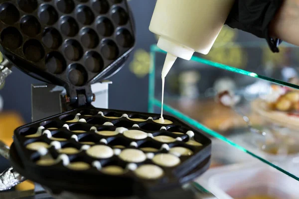 Derramando masa en el fabricante de gofres. Preparación de gofres de Hong Kong . — Foto de Stock