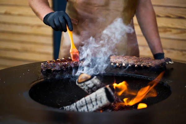 Grillowane żeberka wieprzowe z sosem barbecue na grillu. Festiwal street food. — Zdjęcie stockowe