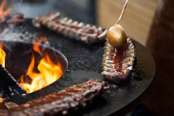 Grilled pork baby ribs with barbecue sauce on the grill. Festival street food. — Stock Photo, Image