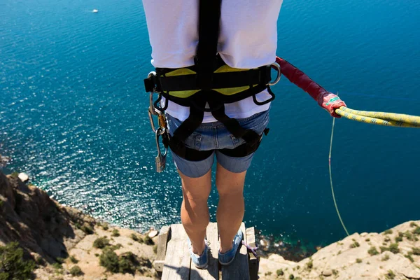 Rope jumping off a cliff with a rope in the water. The ocean. Sea. Mountain.