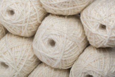 Beyaz arka planda bir sürü beyaz yün iplik.