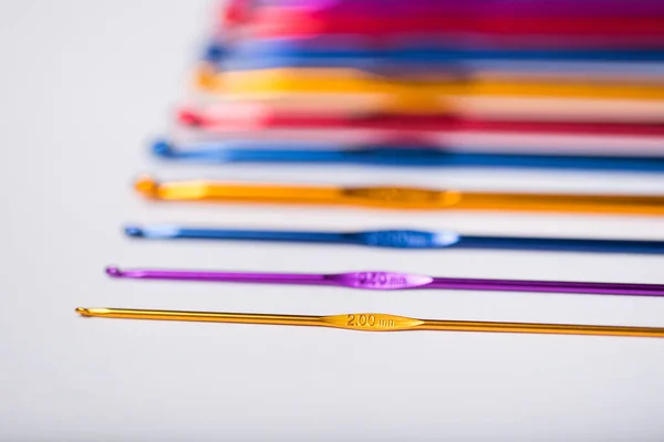 Ganchos coloridos para malha de lã no fundo branco . — Fotografia de Stock