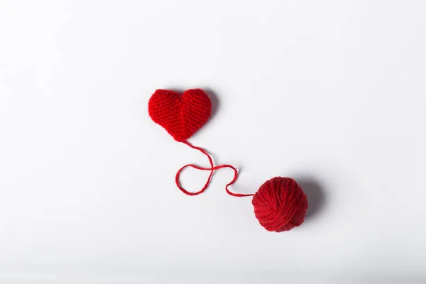 Close-up van een wollen bal en hartvorm op witte achtergrond. Hartvormig wollen garen. Liefde haak. — Stockfoto