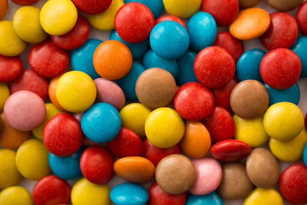 Gros plan d'une pile de bonbons enrobés de chocolat coloré, motif chocolat, fond chocolat . — Photo