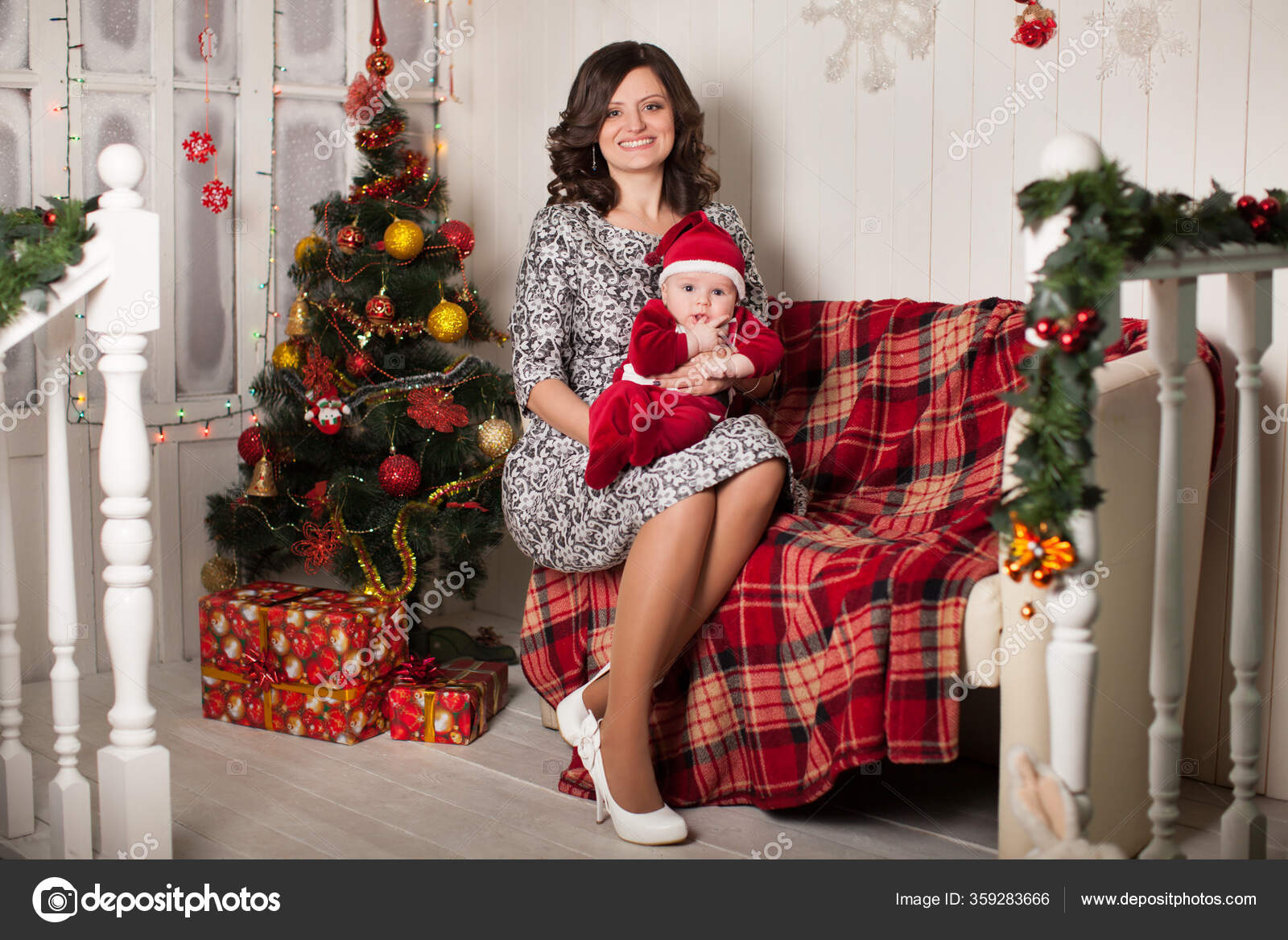 Mutter und Sohn im Weihnachtsmannkostüm vor einer weißen ...