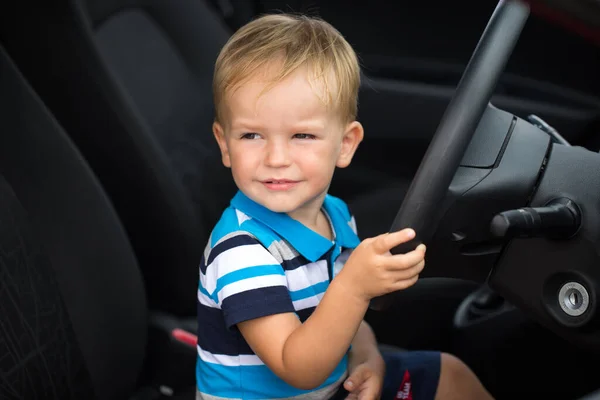 Lindo niño conduciendo el coche de los padres. Niño en el coche —  Fotos de Stock