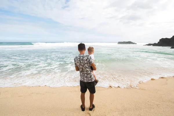 Apa és fia kéz a kézben sétálnak együtt a parton — Stock Fotó