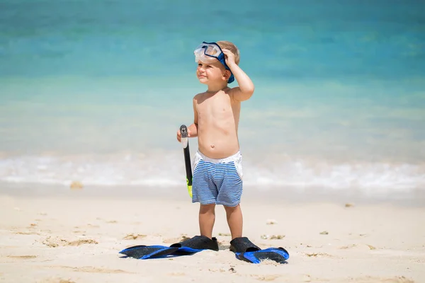 Kleiner Junge mit Tauchermaske und Flossen geht am Strand schwimmen — Stockfoto