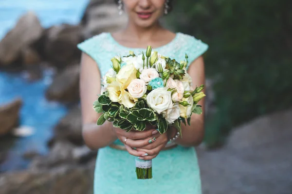 Nevěsta v přírodě v horách u vody. Barva šatů Tiffany. Nevěsta pózuje s kyticí. — Stock fotografie