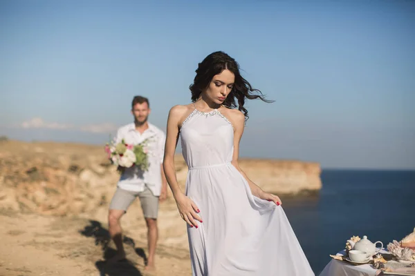 Belo casal jovem em um encontro. O tipo traz flores. . — Fotografia de Stock