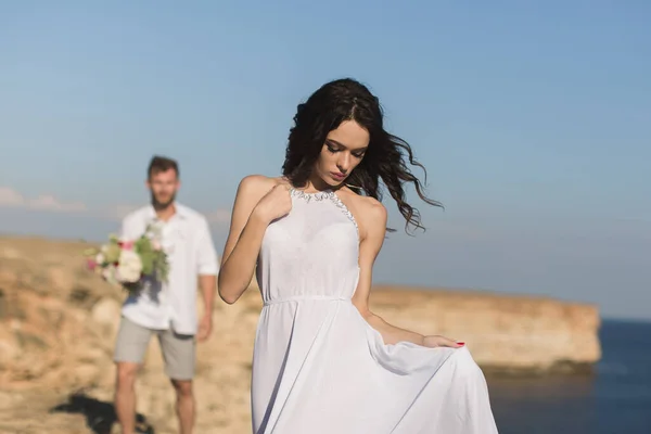 Belo casal jovem em um encontro. O tipo traz flores. . — Fotografia de Stock