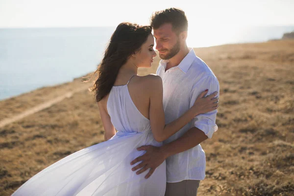 Schönes junges Paar, das sich in der Natur umarmt. Menschen in weißen Kleidern. — Stockfoto