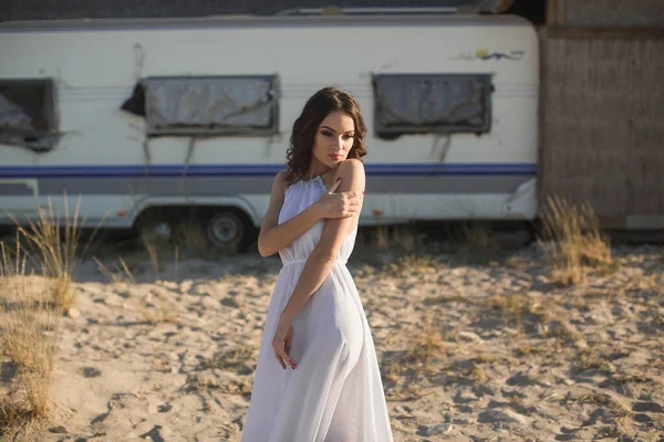 Vacker flicka på stranden, på bakgrunden av trailern van. — Stockfoto