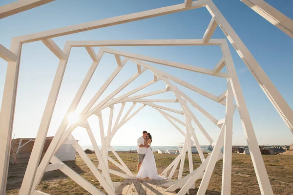 Homme et femme posant. Structures géométriques en bois. La mariée et le marié . — Photo