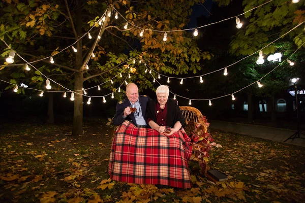 Grandpa and grandma drink tea in the Park.