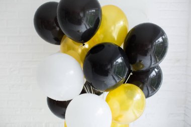 Beyaz tuğla duvarın arka planında renkli balonlar.