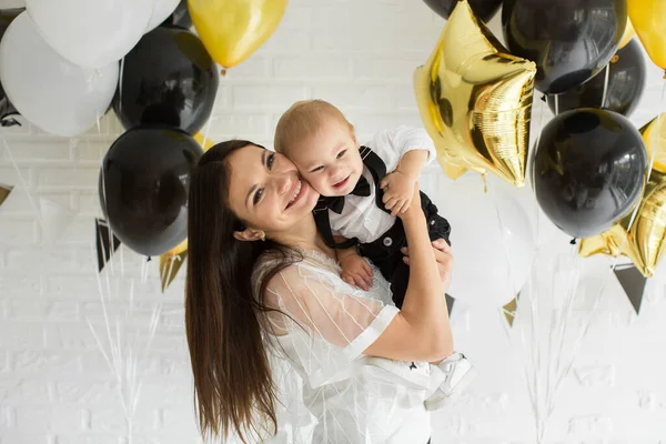 Jonge moeder en zoon met ballonnen. Geboortedatum. — Stockfoto