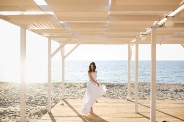 Plajda beyaz elbiseli güzel bir kız.