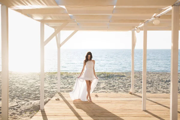 Schöne Mädchen am Strand in einem weißen Kleid. — Stockfoto