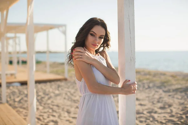 Hermosa chica en la playa en un vestido blanco . — Foto de Stock