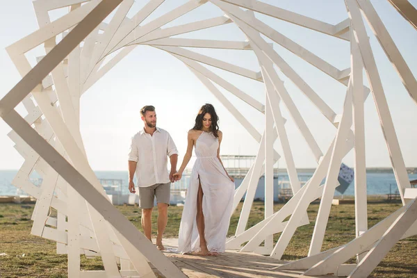 Homem e mulher posando. Estruturas geométricas de madeira. A noiva e o noivo . — Fotografia de Stock