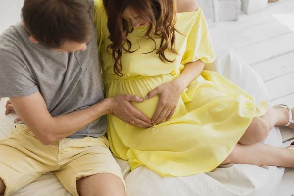 Imagen recortada de la hermosa mujer embarazada y su apuesto marido abrazando la barriga . — Foto de Stock