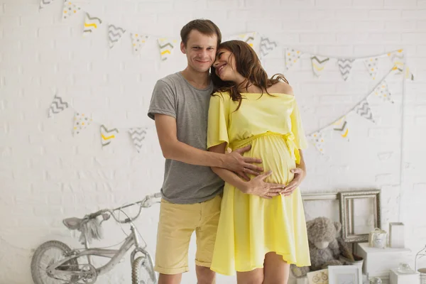 Zwangere vrouw met echtgenoot in de studio. — Stockfoto