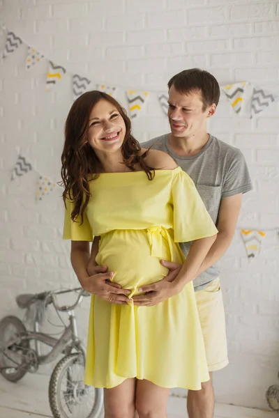 Ik wacht op de baby. gelukkig man knuffelen zijn zwanger vrouw. — Stockfoto