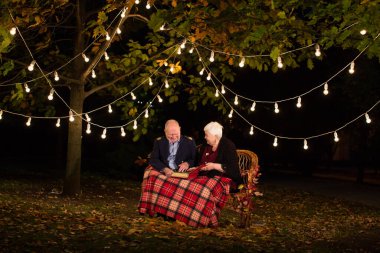Parktaki mutlu yaşlı çift, büyükanne ve büyükbaba. Fotoğraf albümüne bak..