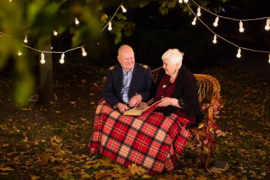 Parktaki mutlu yaşlı çift, büyükanne ve büyükbaba. Fotoğraf albümüne bak..
