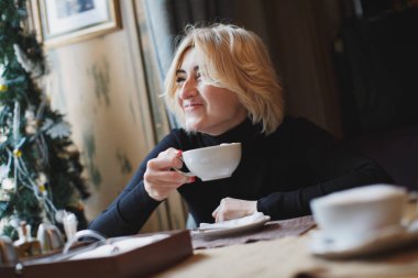 Güzel bir kadın beyaz bardaktan kahve içiyor..