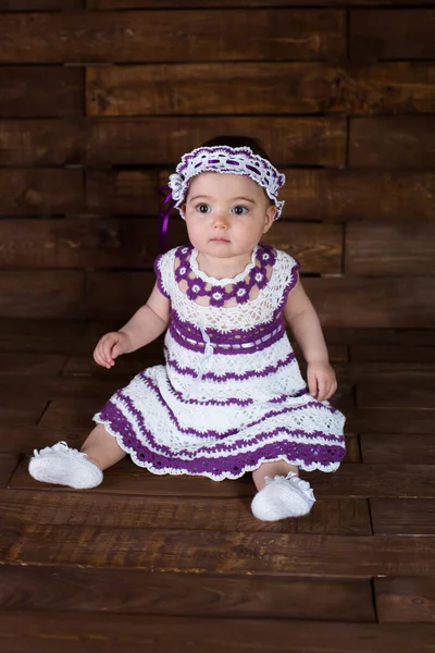 Beautiful girl in pink dress on a wooden background. — Stock Photo, Image