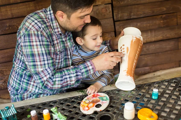 Отец и сын рисуют вазу на деревянной стене. . — стоковое фото