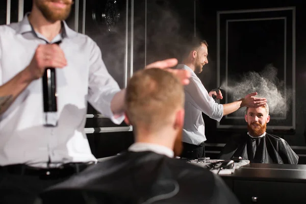 Saç spreyi. Bir berberin portresi müşterinin saçına su püskürtüyor.. — Stok fotoğraf