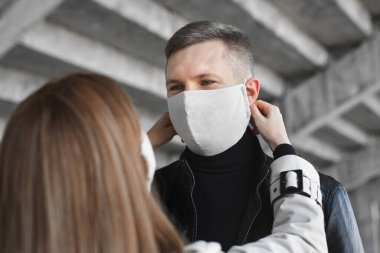 Bir kadın bir erkeğin yüzüne koruyucu maske takar. Coronavirus, covid19