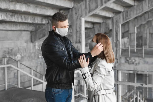 Un uomo mette una maschera protettiva sul viso di una donna. Il Coronavirus, Covid-19 — Foto Stock