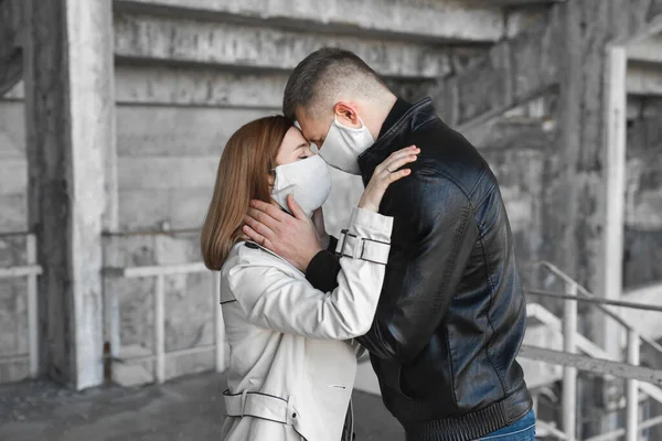 Casal apaixonado, homem e mulher se beijando em máscara médica protetora no rosto. Guy, rapariga contra o coronavírus pandémico, protecção contra o vírus. Covsd19 — Fotografia de Stock