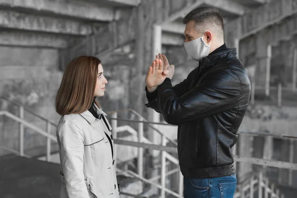 Un uomo mascherato mostra a una donna uno stop per il coronavirus. La pandemia del 2020. Fermate il Covid19. Quarantena. Vaccino al coronavirus . — Foto Stock